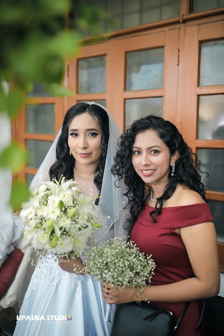 Two beautiful brides in wedding gowns, radiating happiness, pose side by side | upasna studio | wedding photographer in Delhi.