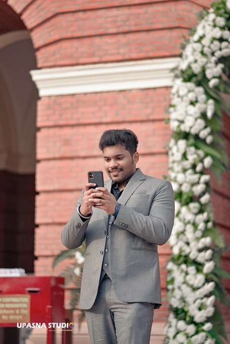 Best Photographers in Delhi | A man in a suit capturing a selfie on his phone.